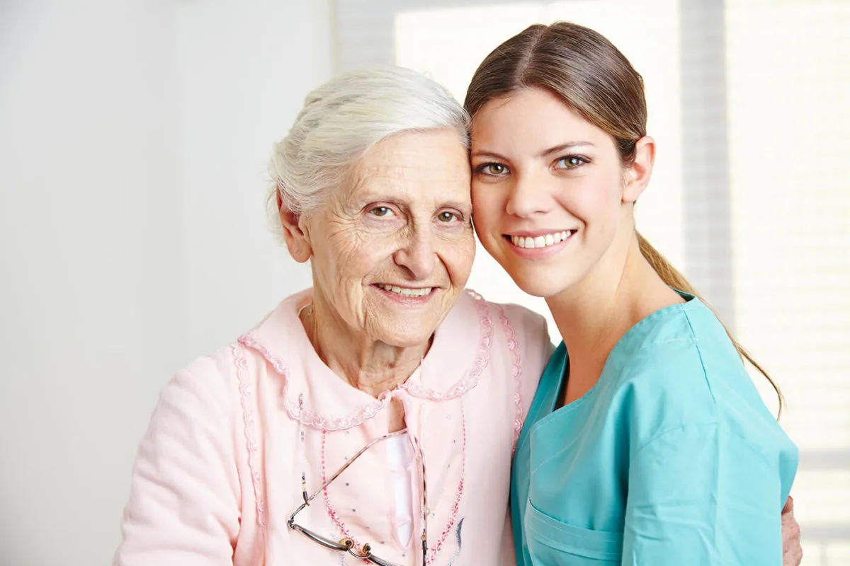 Smiling older woman with her live-in carer at home